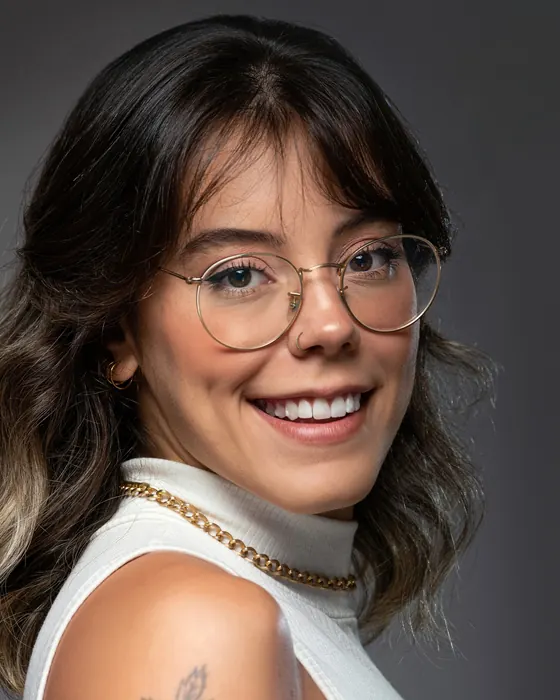 Mulher de peça clara e óculos em retrato corporativo de estúdio