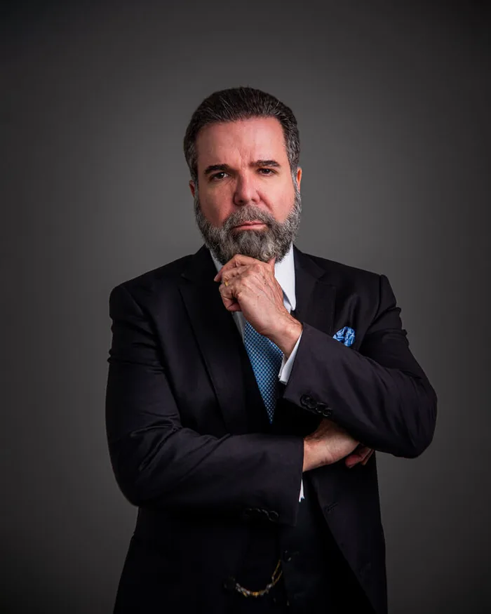 Homem de terno escuro e gravata em retrato corporativo de estúdio